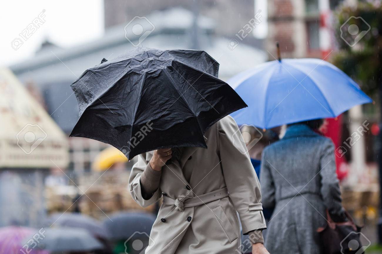 people walking with umbrellas in the rainy city - 53689899 people walking with umbrellas in the rainy city - 53689899