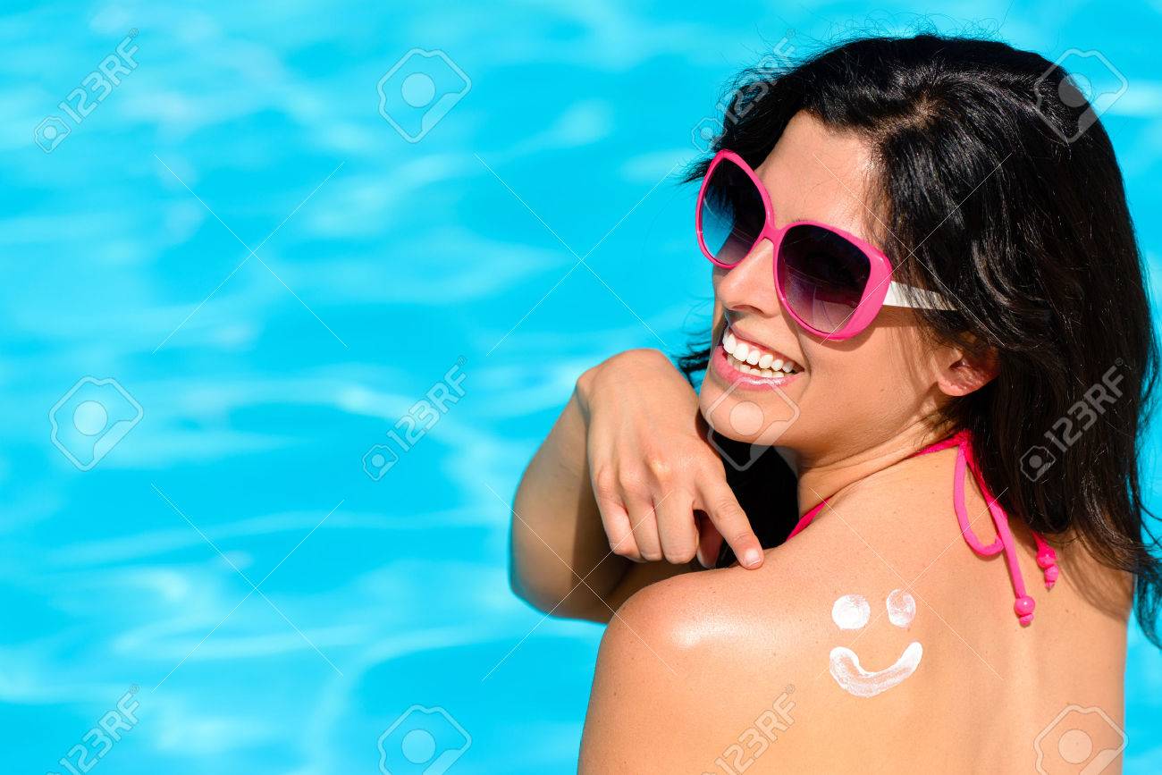 幸せな女性の彼女の背中に日焼け止めローションおかしいスマイリーを指すとスイミング プールで夏休みを楽しんでいます 日光浴の美しいブルネット 皮膚のケアと太陽保護の概念 の写真素材 画像素材 Image 4515
