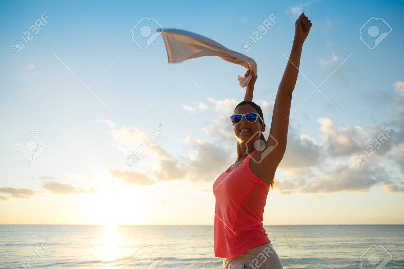 Fitness happy woman celebrating fitness workout success towards the sea and sunset at the beach. Training motivation and healthy lifestyle concept. - 55458520 Fitness happy woman celebrating fitness workout success towards the sea and sunset at the beach. Training motivation and healthy lifestyle concept. - 55458520