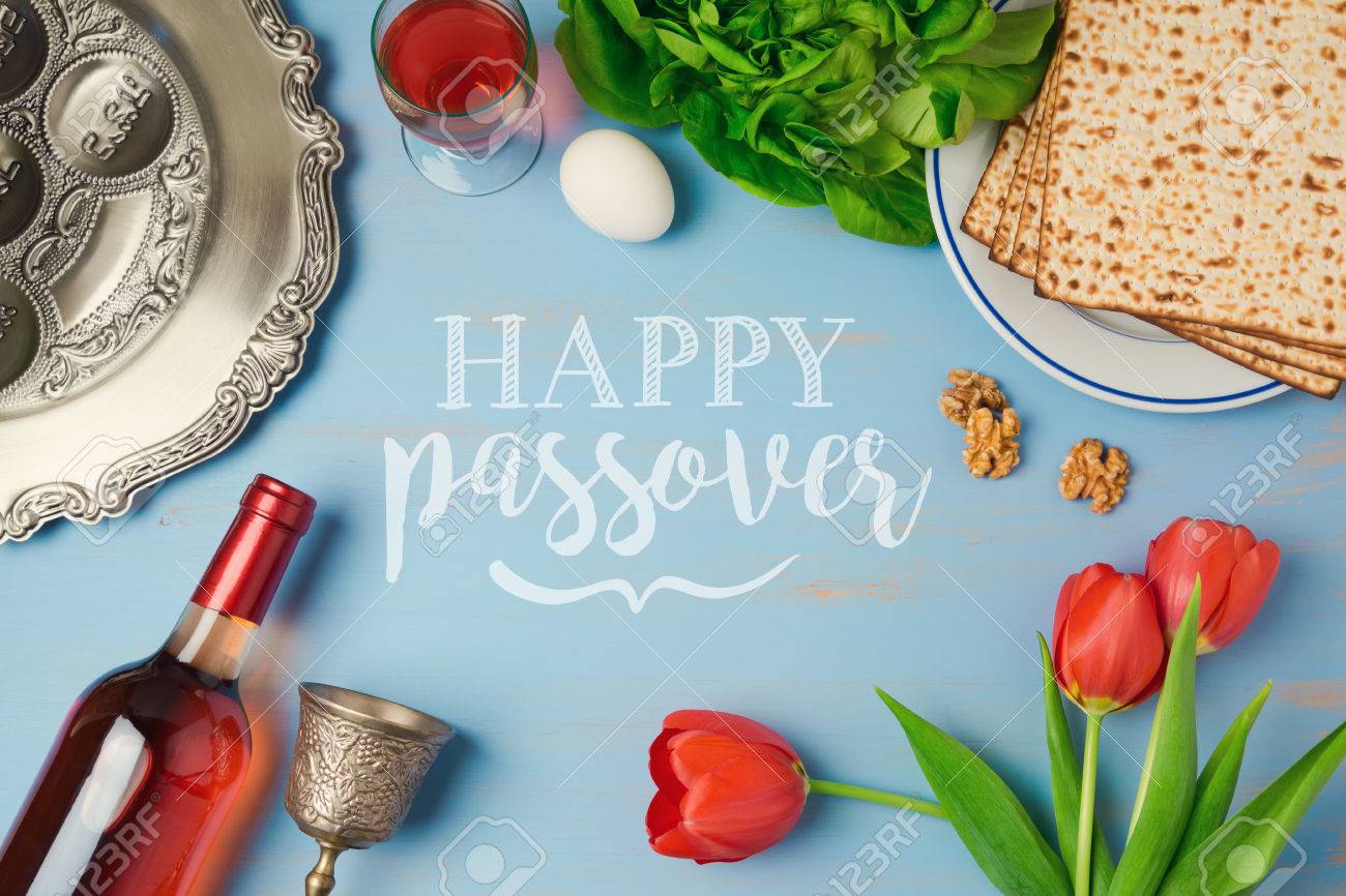 Passover holiday greeting card with seder plate, matzoh, tulip flowers and wine bottle on wooden background. Top view from above - 73346710 Passover holiday greeting card with seder plate, matzoh, tulip flowers and wine bottle on wooden background. Top view from above - 73346710