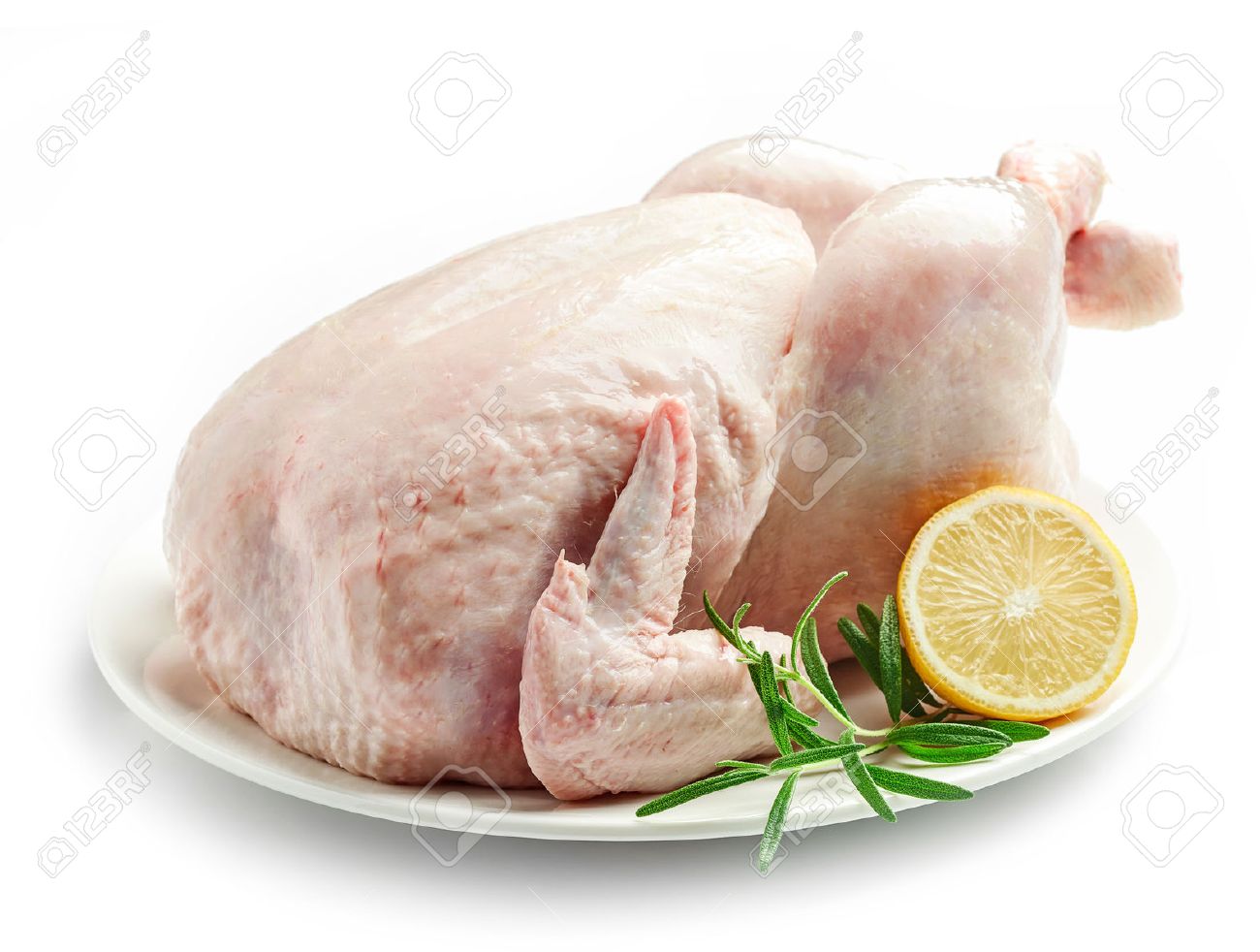 whole raw chicken on plate isolated on white background stock photo