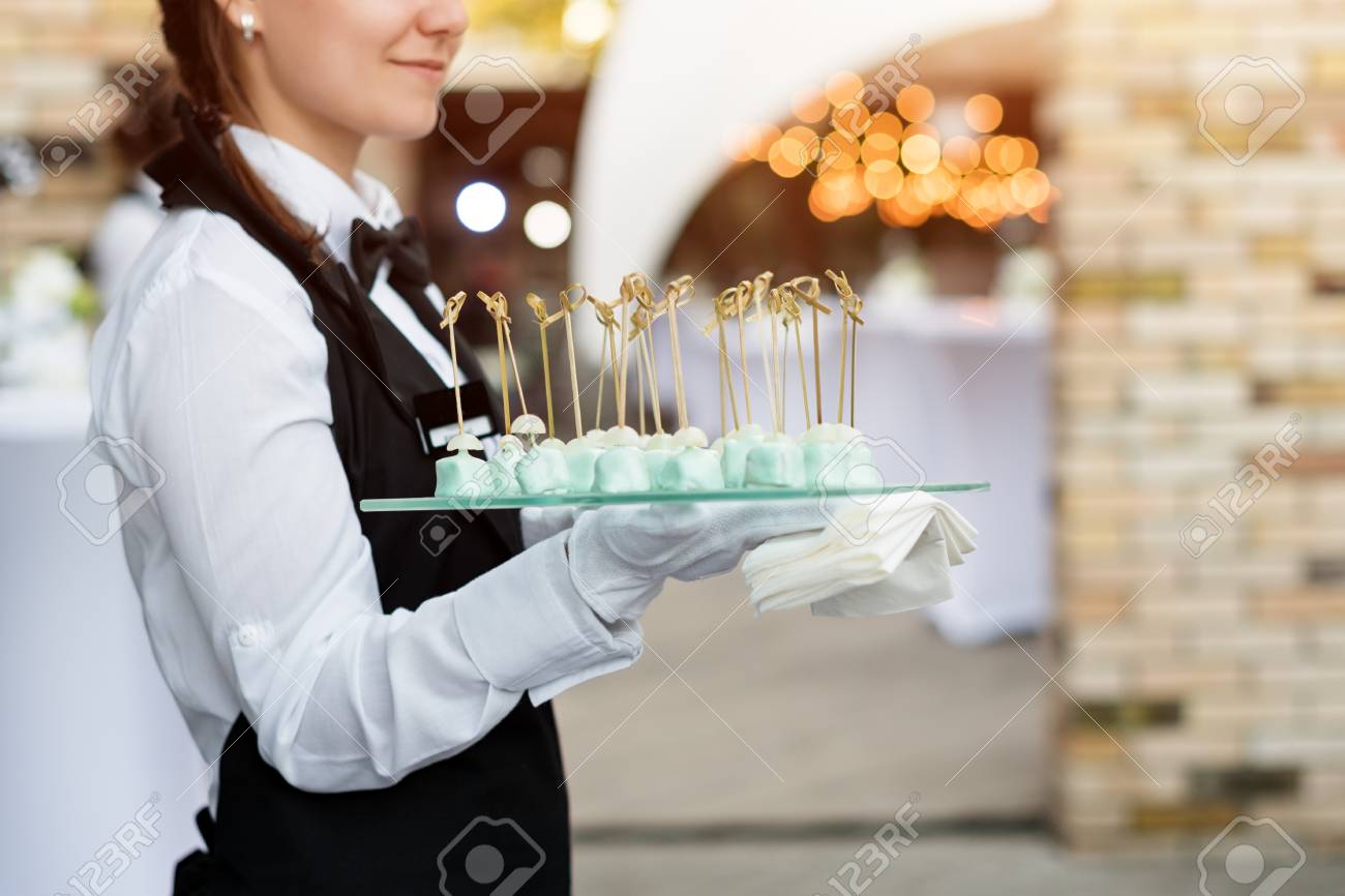 catering service waiter carrying a tray of appetizers outdoor catering waiter