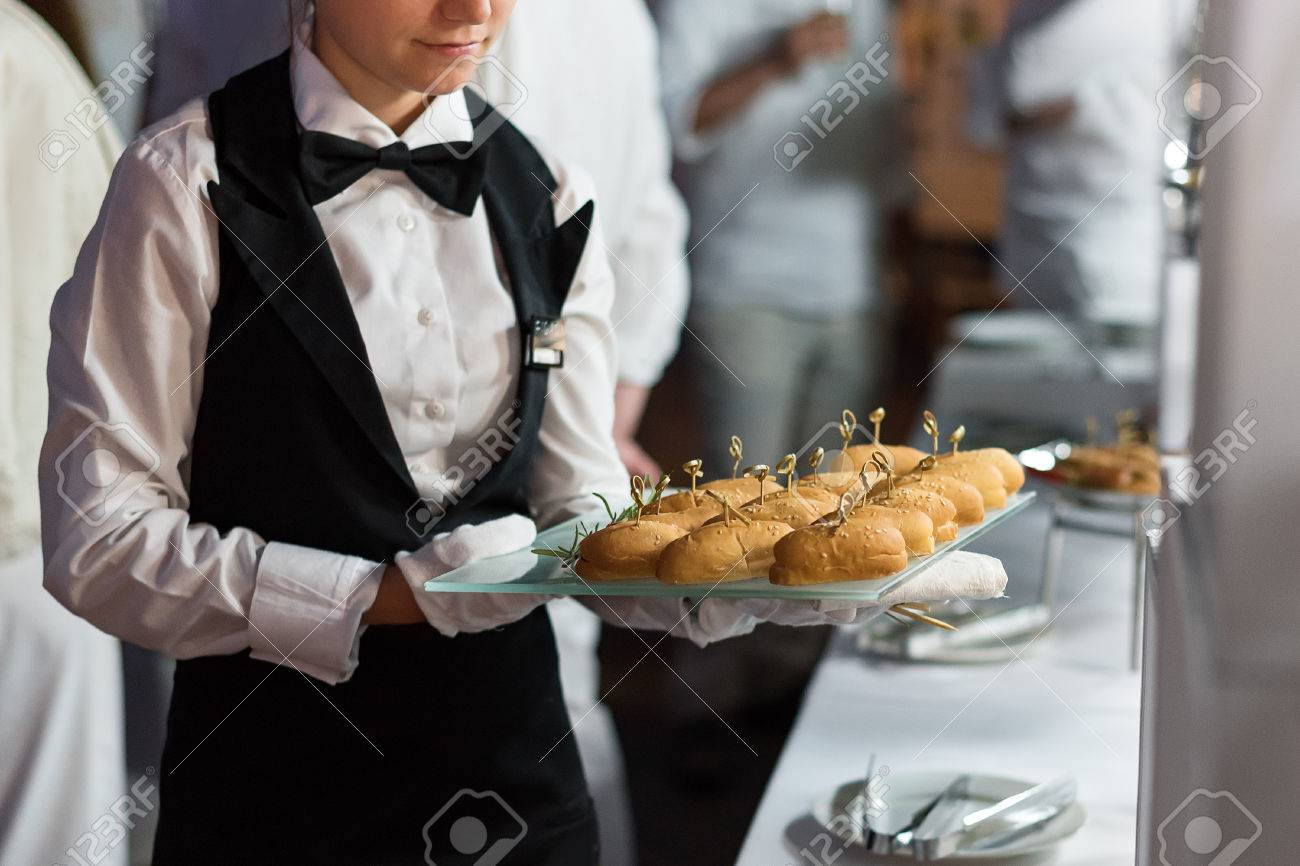 catering service waiter carrying a tray of appetizers outdoor catering waiter