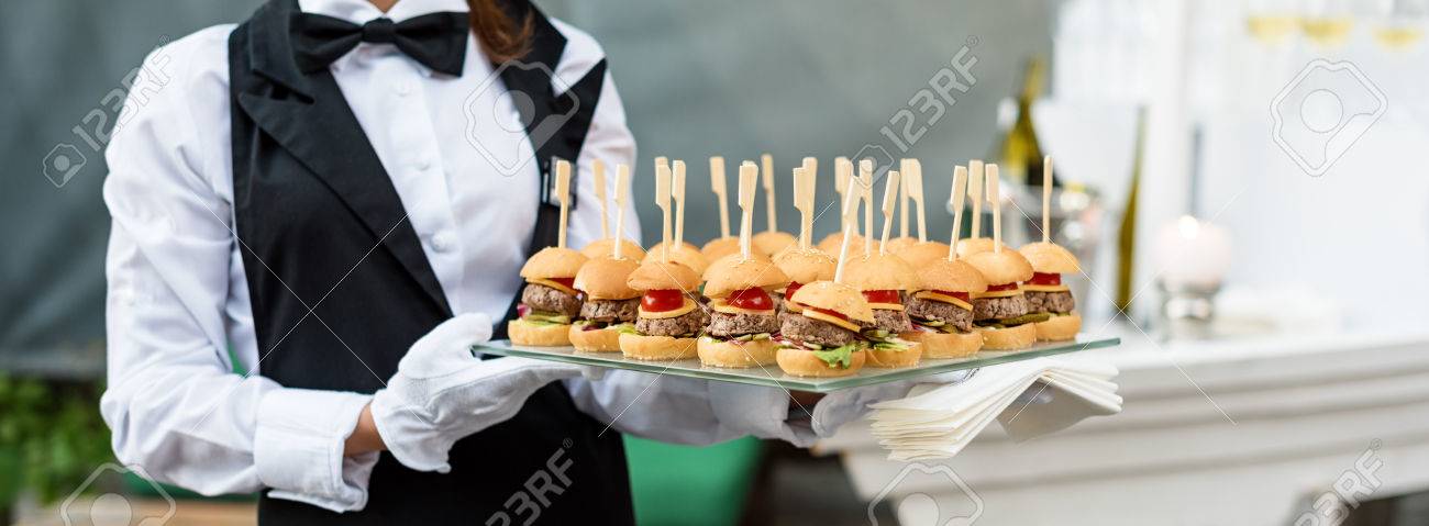 catering service waiter carrying a tray of appetizers outdoor catering waiter