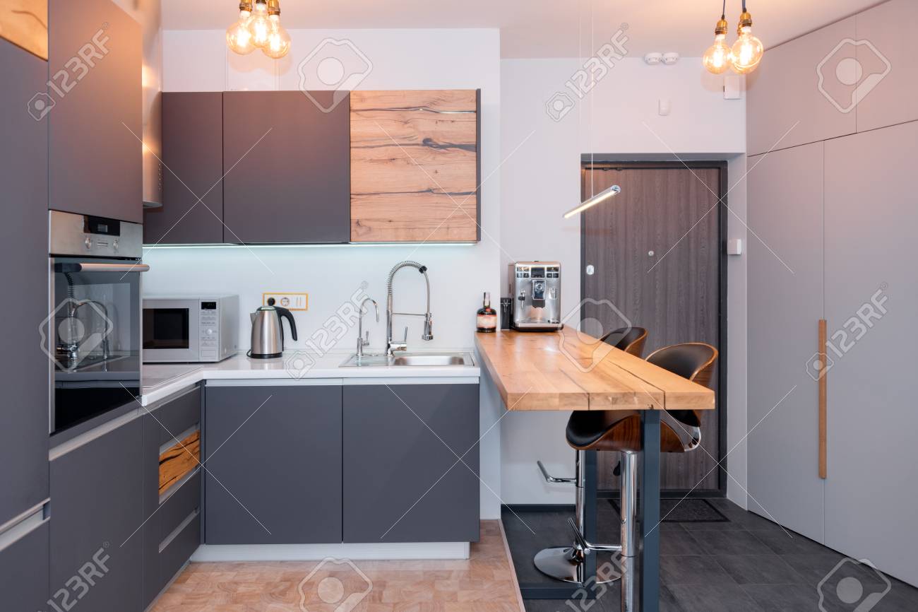 Modern Kitchen Interior With Lights On Brown Wooden Table And Stock Photo