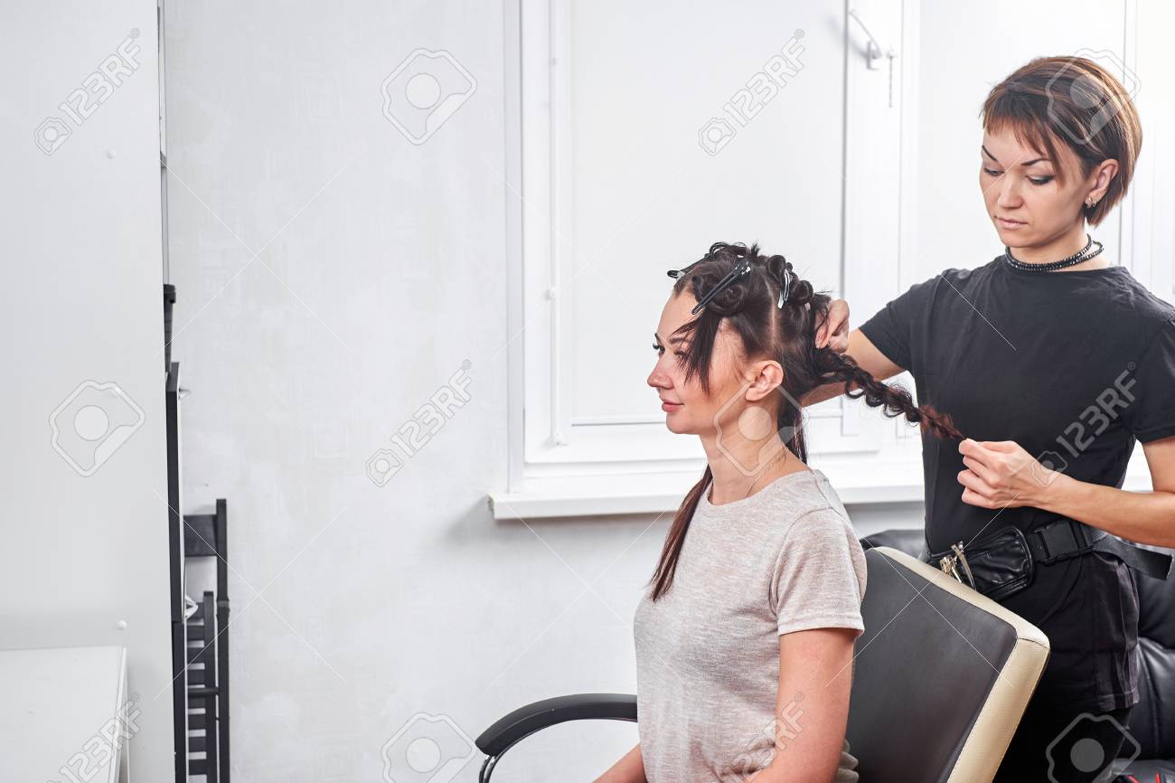 Hair Stylist Making New Haircut To Brunette Woman In Salon