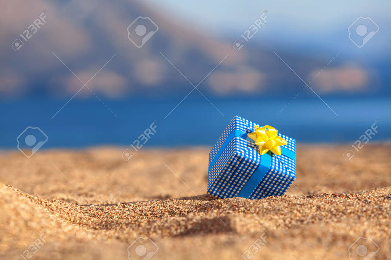 Blue gift box on a beach - 36973615 Blue gift box on a beach - 36973615