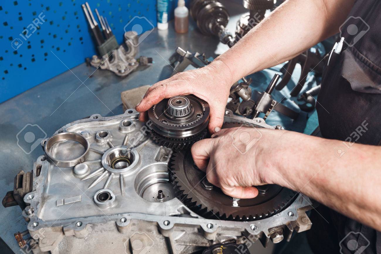 Cross-section of a car gearbox. mechanics work in the garage. hand car mechanic in working clothes. - 67027593 Cross-section of a car gearbox. mechanics work in the garage. hand car mechanic in working clothes. - 67027593
