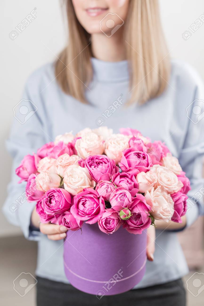 Bukiet Kwiatów W Fioletowym Wlewu. Młoda Szczęśliwa Kobieta Trzyma Piękny Bukiet  Róż. Prezent Dla Dziewczyny Z Uśmiechem. Słoneczny Wiosenny Poranek.  Zdjęcia royalty free, obrazki, obrazy oraz fotografia seryjna. Image  97452545