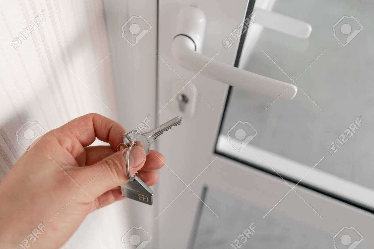 Modern light lobby interior. Men hand holding key with house keychain. Real estate, moving home or renting property. Mortgage concept. - 128415962 Modern light lobby interior. Men hand holding key with house keychain. Real estate, moving home or renting property. Mortgage concept. - 128415962