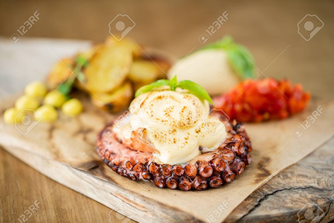 Roasted octopus BBQ with Baked potato. Wooden plate. Restaurant menu - 130485029 Roasted octopus BBQ with Baked potato. Wooden plate. Restaurant menu - 130485029