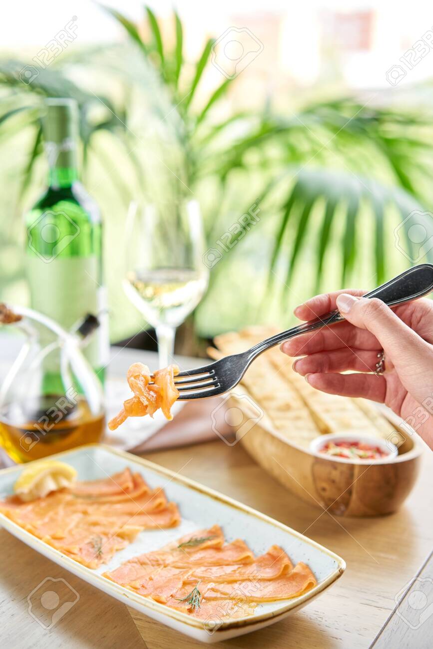 Closeup of salted and smoked salmon or trout fillet on a fork . Thin slices of red fish with lemon close up. Restaurant menu - 133699085 Closeup of salted and smoked salmon or trout fillet on a fork . Thin slices of red fish with lemon close up. Restaurant menu - 133699085