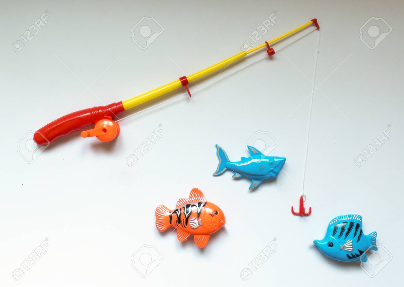 Lustig, Spielzeug Hintergrund über Das Angeln Lizenzfreie Spielzeug Angelrute auf weißem Hintergrund Stockfotografie