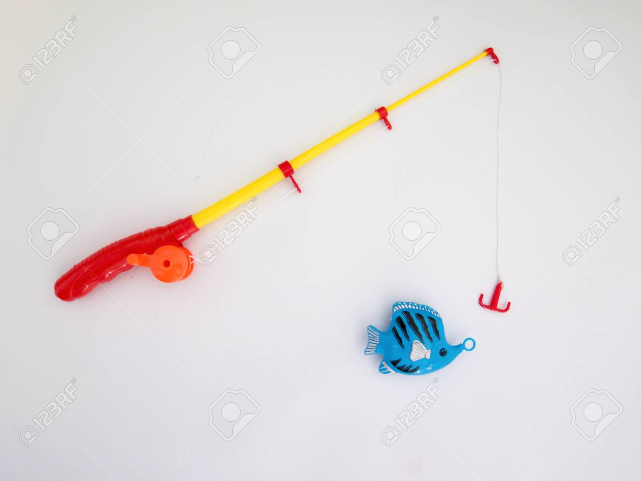 Angeln Spielzeug, Weißer Hintergrund, Kunststoff Lizenzfreie Spielzeug Angelrute auf weißem Hintergrund Stockfotografie