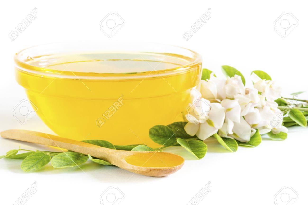 Honey in glass bowl and acacia on white background - 19793115 Honey in glass bowl and acacia on white background - 19793115