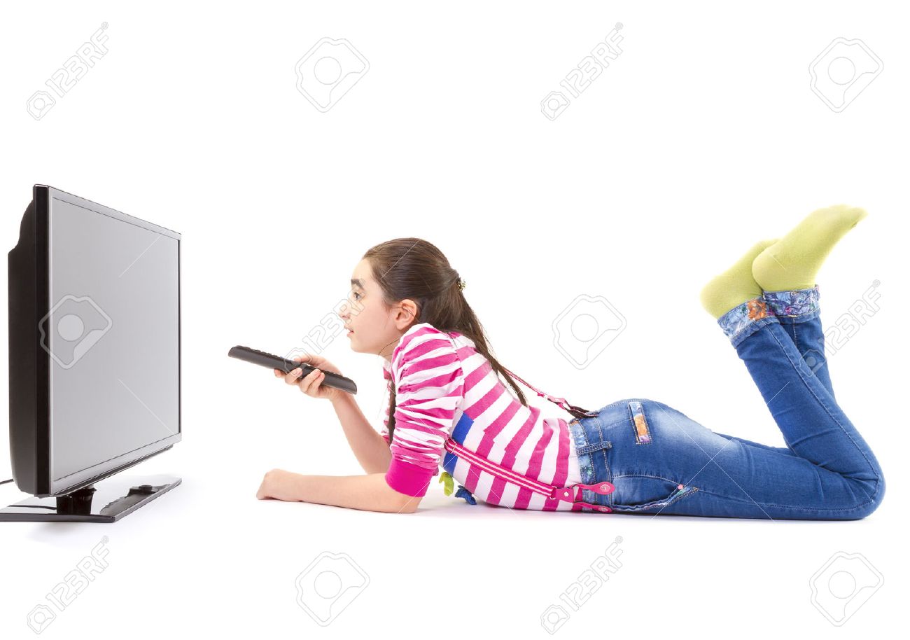 Happy little girl laying down and watching tv - 27351628 Happy little girl laying down and watching tv - 27351628