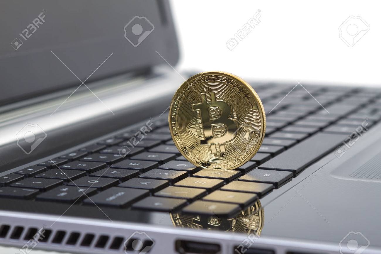 Studio shot of golden Bitcoin virtual currency on laptop. Close-up of front side. - 29292834 Studio shot of golden Bitcoin virtual currency on laptop. Close-up of front side. - 29292834