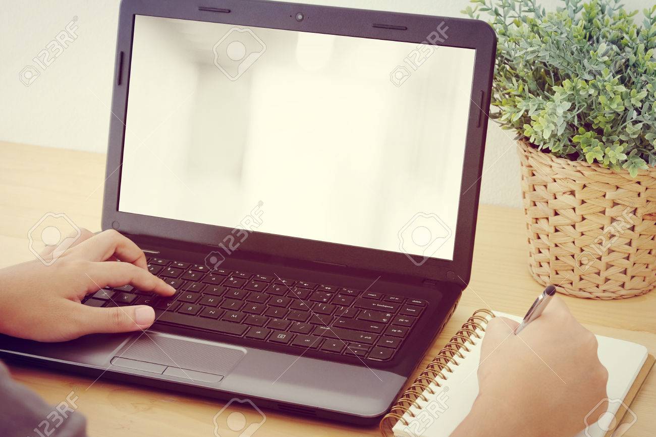 hand typing laptop and writing on notebook background for mock