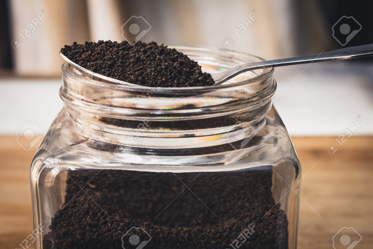 View of finest tea powder in a spoon placed over a glass container. Common dust tea used in India - 165099543 View of finest tea powder in a spoon placed over a glass container. Common dust tea used in India - 165099543