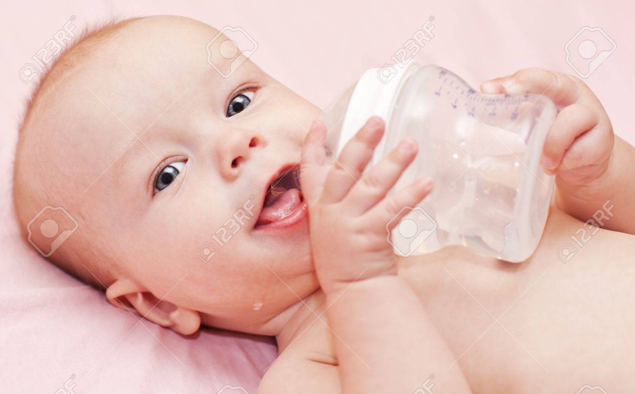 カメラを見てボトルや飲み物水を保持している幸せな赤ちゃん の写真素材 画像素材 Image