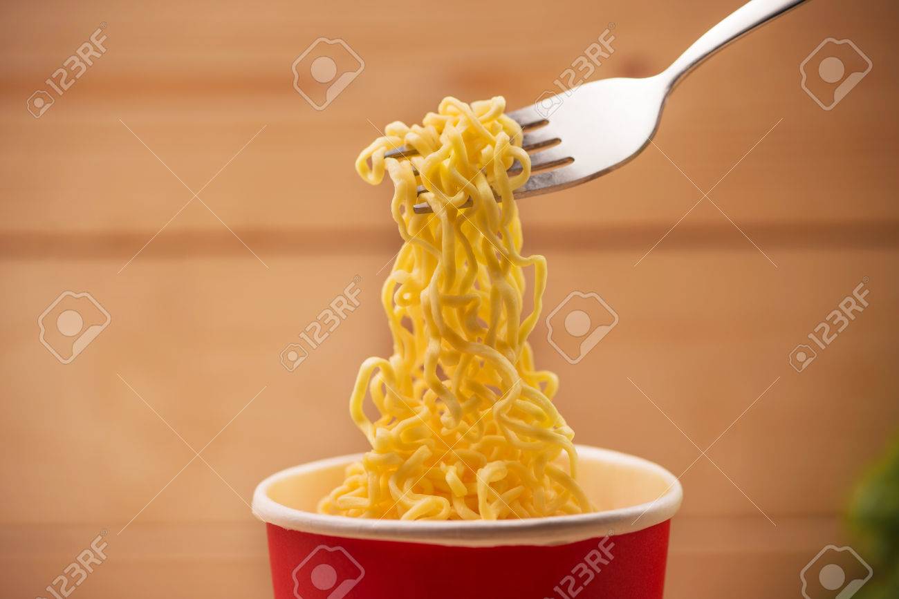 Eating Instant Noodles In Cup With A Fork Stock Photo, Picture And Royalty  Free Image. Image 80105895.