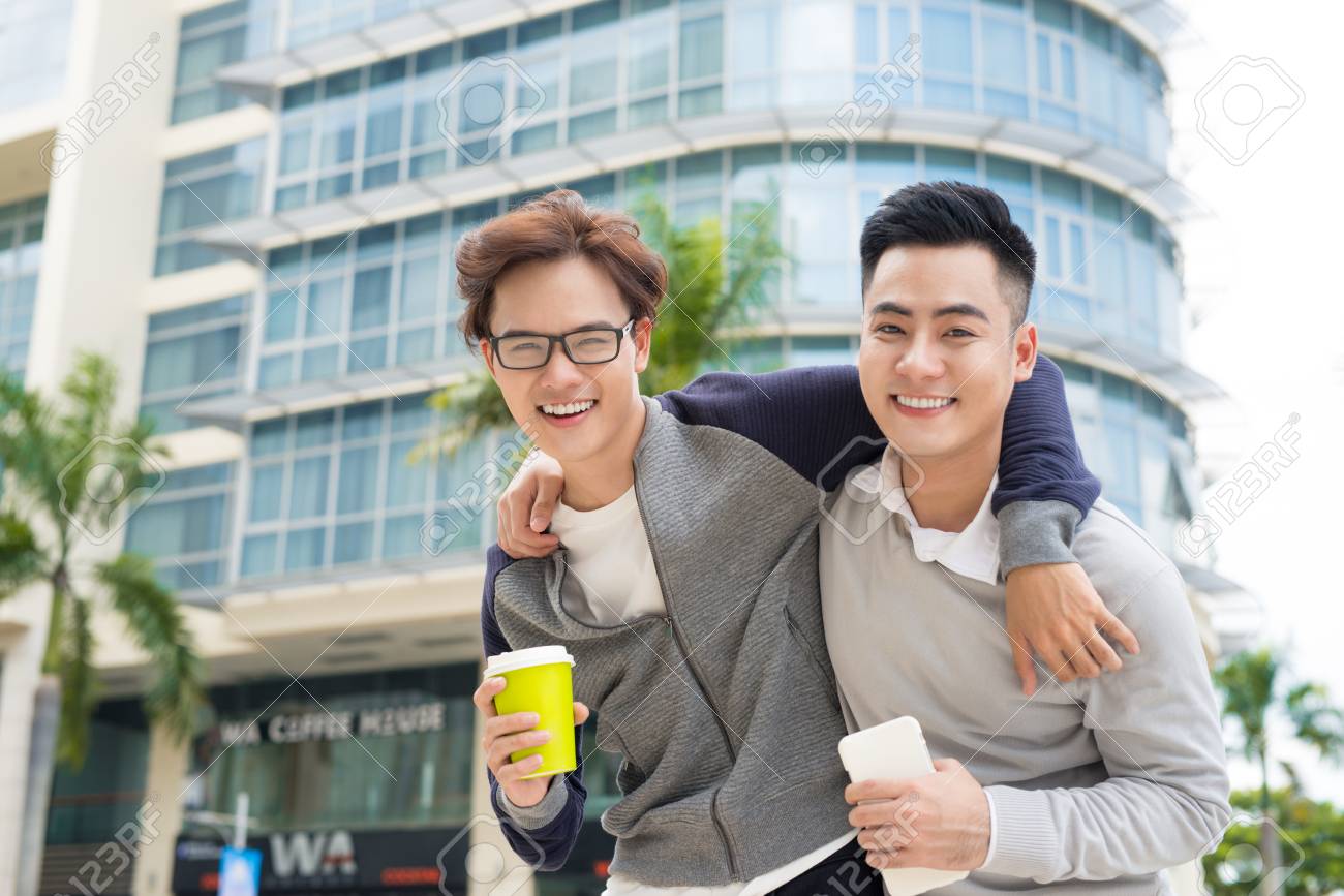 Best Friends. Two Guys Hugging And Walking In The City. Stock 