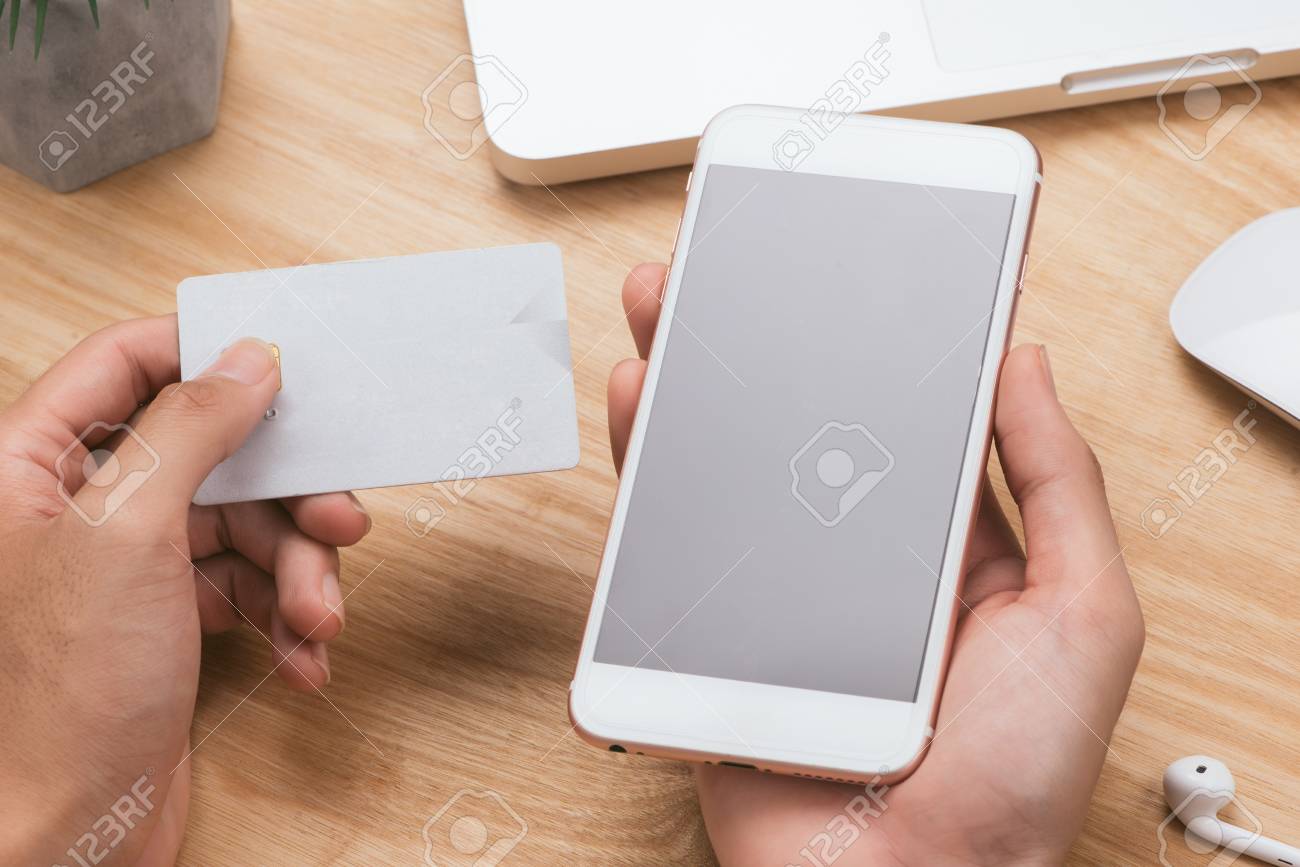 Hands holding credit card, smart phone and using laptop. Online shopping concept-vintage tone and flare filtered - 117026492 Hands holding credit card, smart phone and using laptop. Online shopping concept-vintage tone and flare filtered - 117026492
