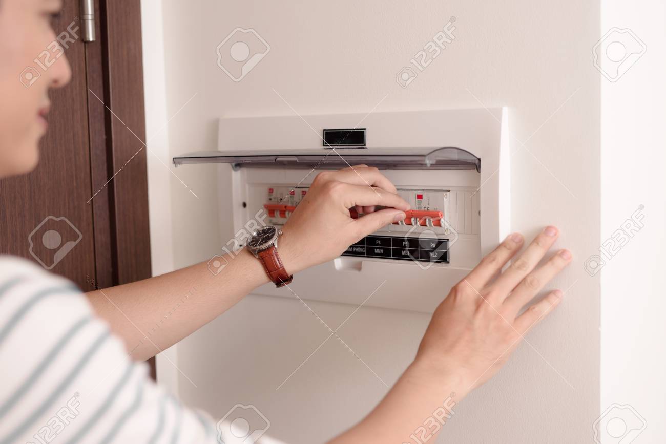 Hand including the switch on the electric panel - 117406929 Hand including the switch on the electric panel - 117406929
