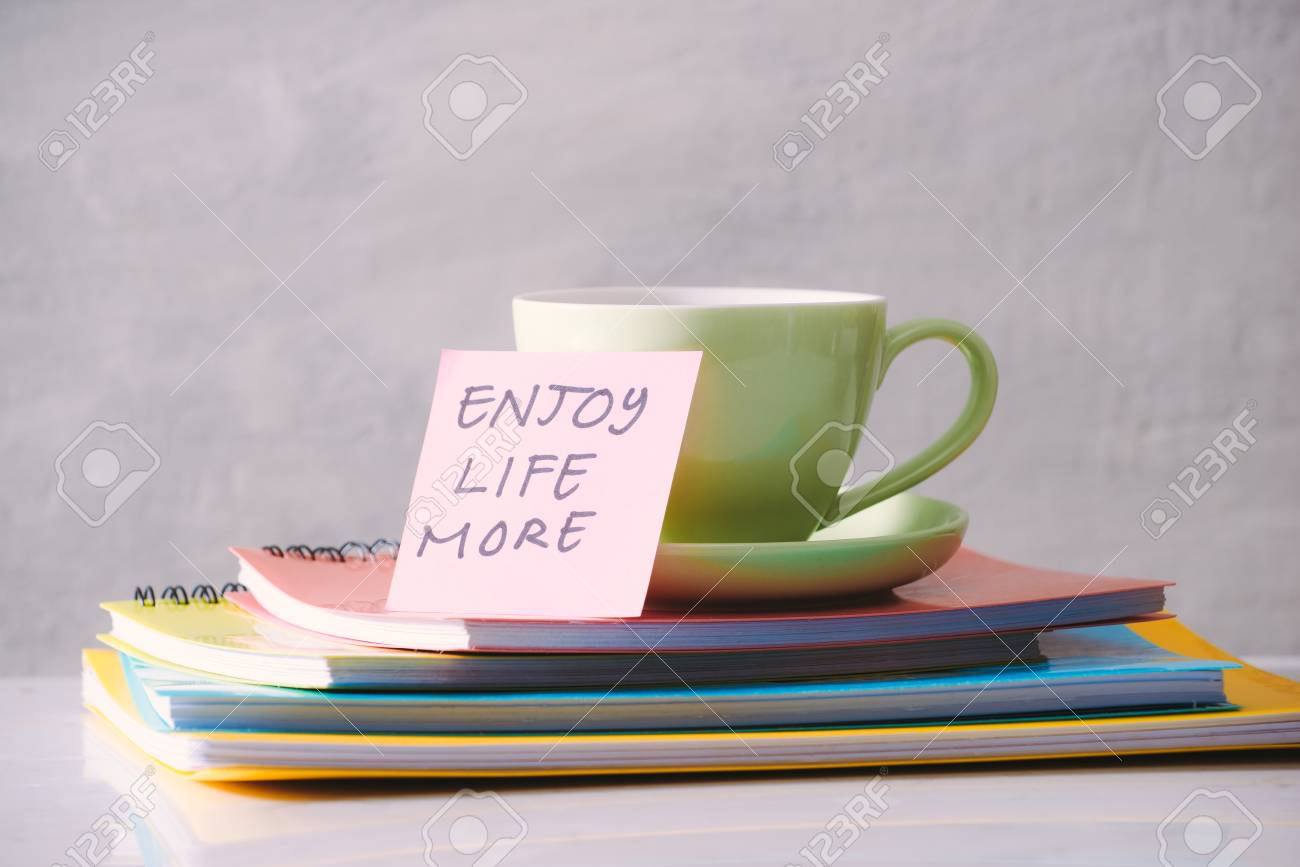 Green cup with sticker and notebooks on tabletop. - 119039224 Green cup with sticker and notebooks on tabletop. - 119039224