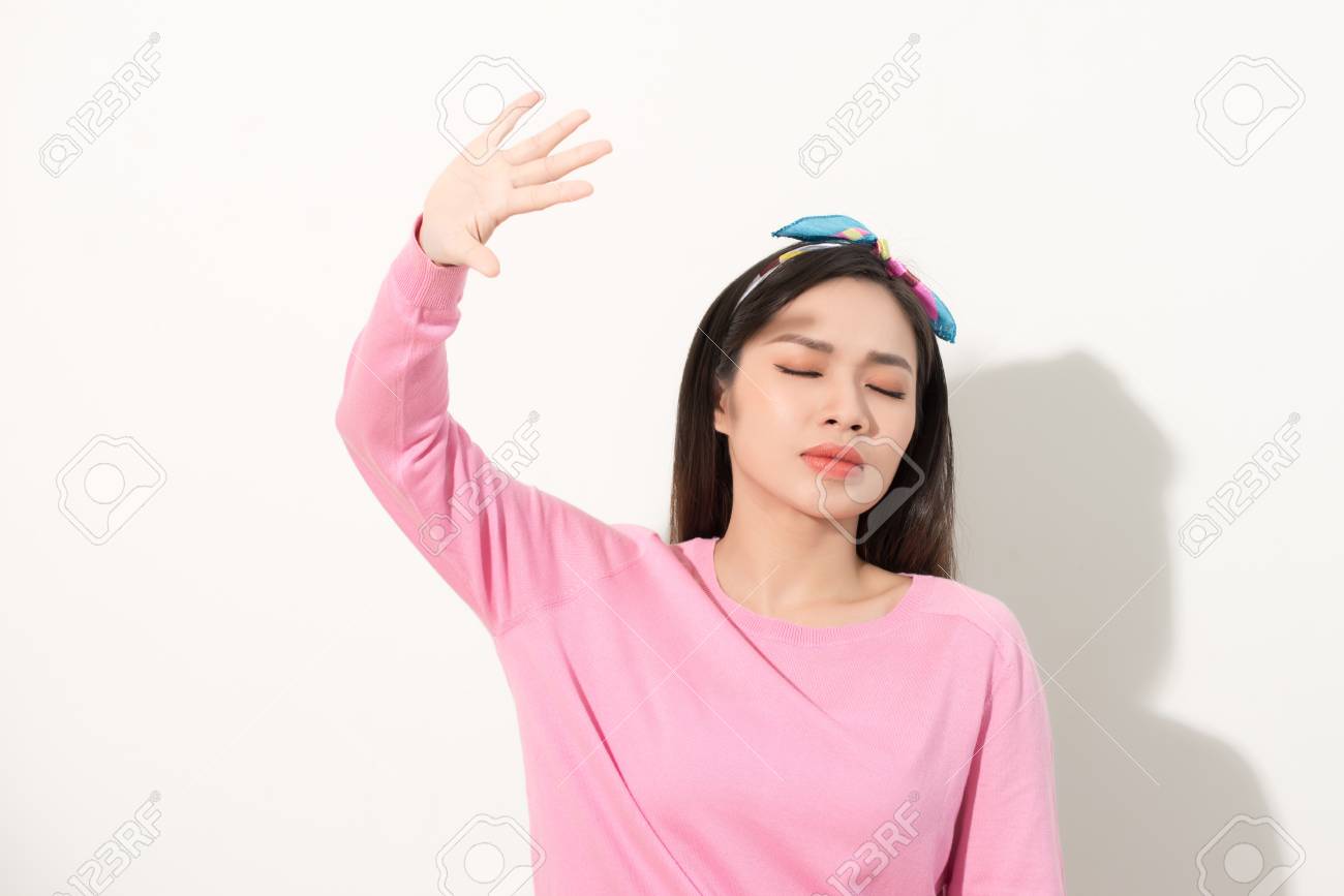 Portrait of a beautiful Asian girl covering face by hand of bright sun light. woman in a pink dress protecting her face from solar light. Skin care or beauty concept - 121249199 Portrait of a beautiful Asian girl covering face by hand of bright sun light. woman in a pink dress protecting her face from solar light. Skin care or beauty concept - 121249199