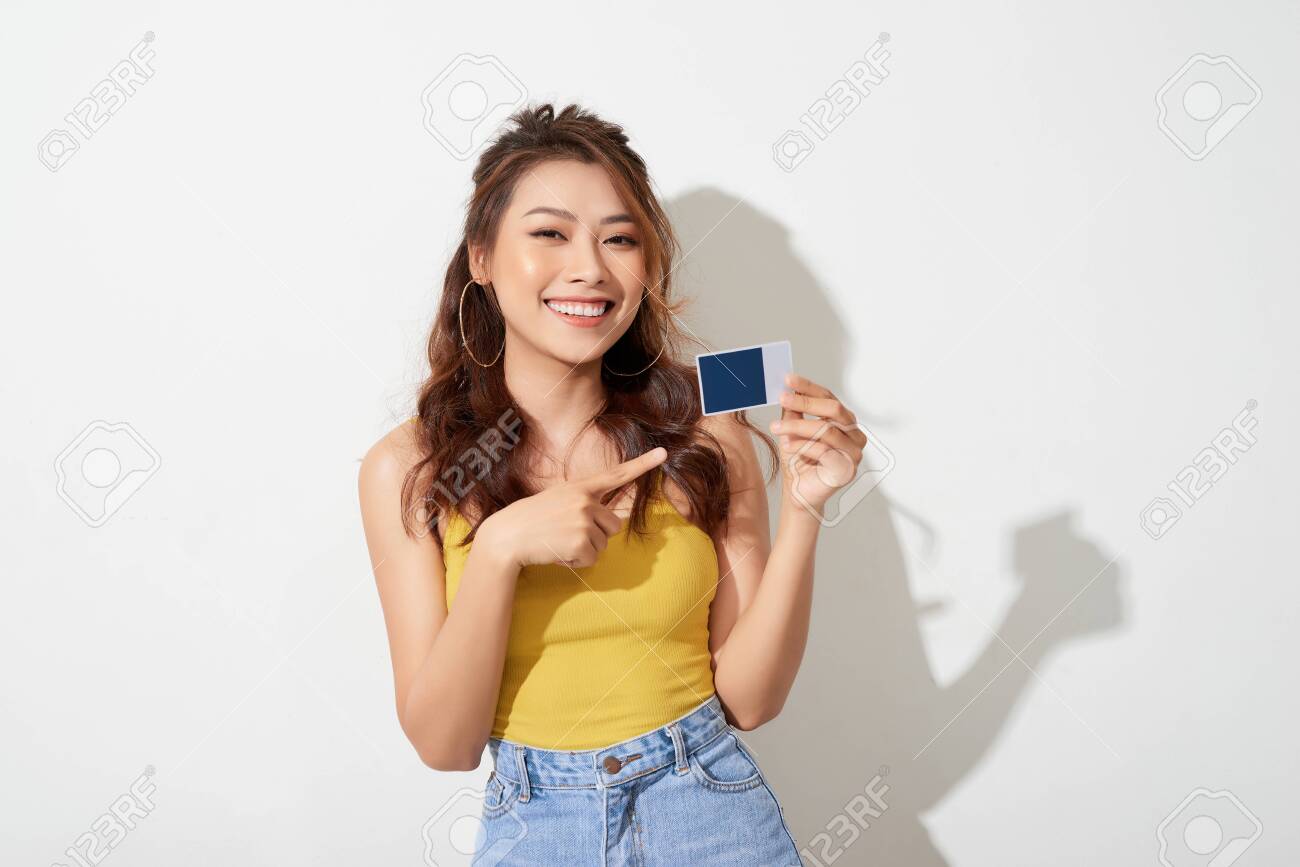 Photo of young smiling asian woman holding card - 122824693 Photo of young smiling asian woman holding card - 122824693