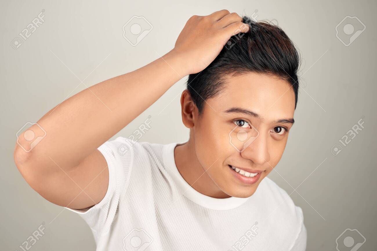 Close up portrait of handsome Asian man touching his perfect hair - 125687880 Close up portrait of handsome Asian man touching his perfect hair - 125687880