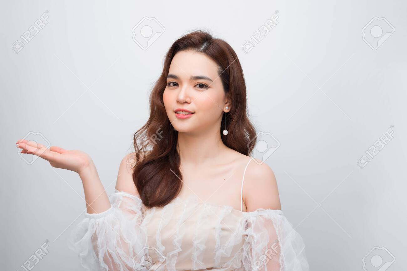 Body skincare care beauty Asian woman showing product on side with open hand - 126710499 Body skincare care beauty Asian woman showing product on side with open hand - 126710499