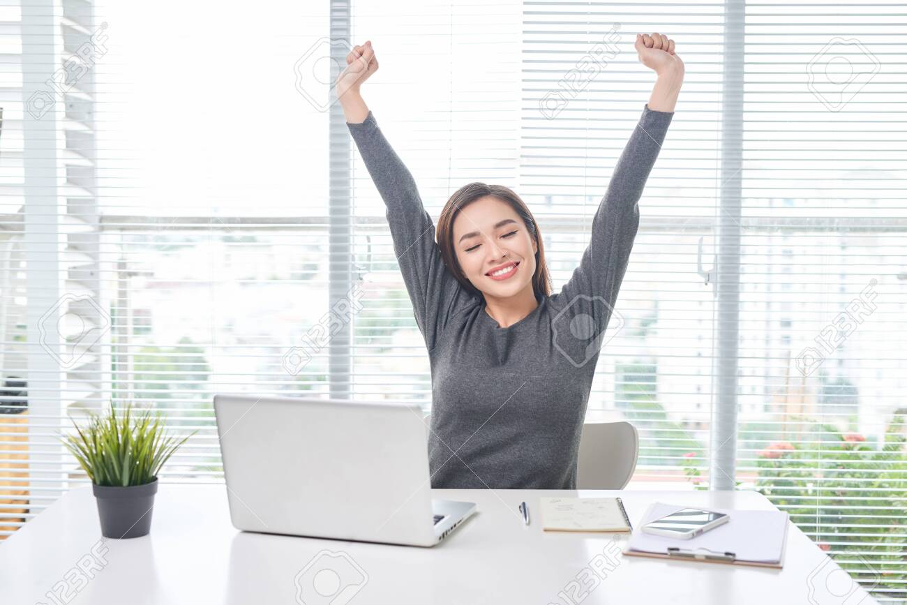 Satisfied woman relaxing with hands behind her head. Happy smiling employee after finish work, reading good news, break at work, girl doing simple exercise, relieve muscle stress, feeling well - 126710524 Satisfied woman relaxing with hands behind her head. Happy smiling employee after finish work, reading good news, break at work, girl doing simple exercise, relieve muscle stress, feeling well - 126710524
