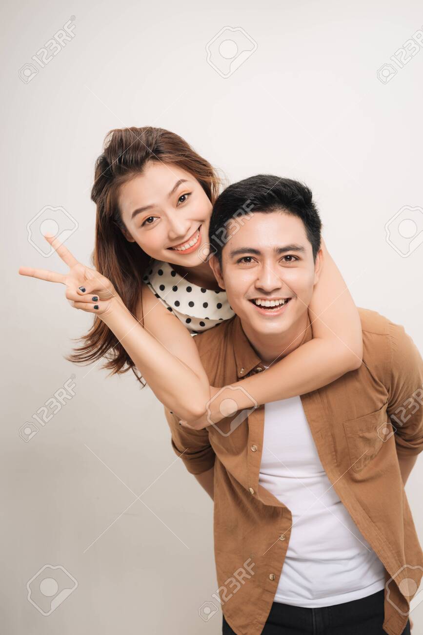 man carrying his lover on back, woman showing peace symbol over white background - 131919951 man carrying his lover on back, woman showing peace symbol over white background - 131919951