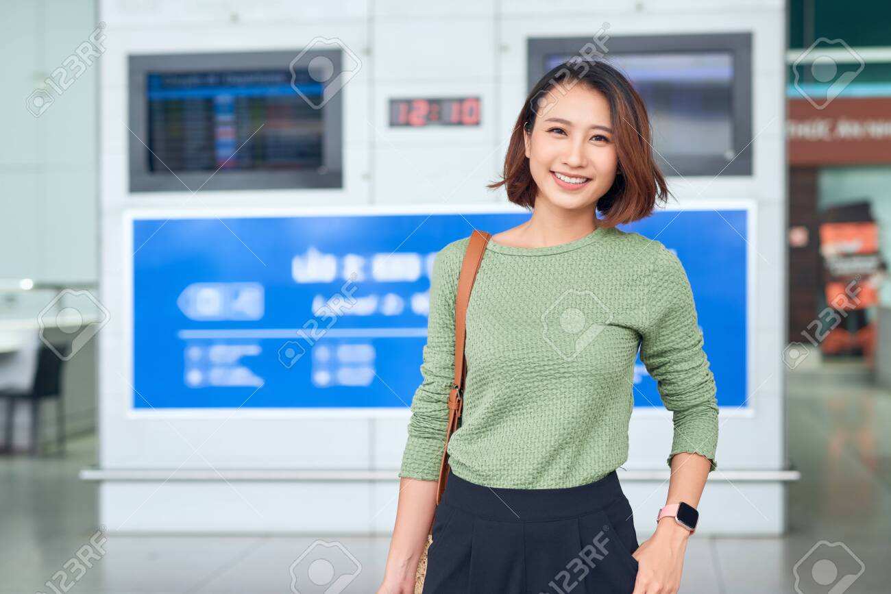Travel. Young woman goes at airport at window with suitcase waiting for plane - 133119968 Travel. Young woman goes at airport at window with suitcase waiting for plane - 133119968