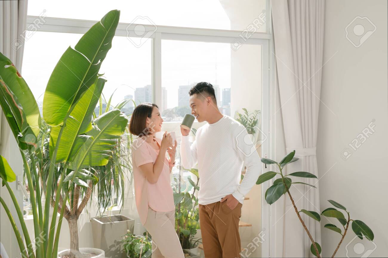 happy couple relaxing together at home with cup of coffee - 135647345 happy couple relaxing together at home with cup of coffee - 135647345