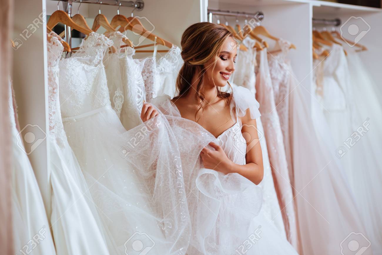 Beautiful bride is trying on an elegant wedding dress - 110131256 Beautiful bride is trying on an elegant wedding dress - 110131256
