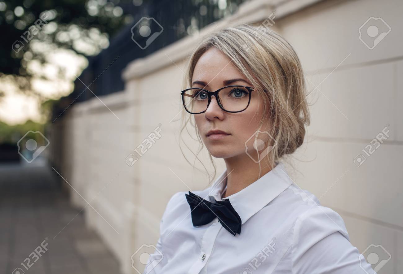 眼鏡 白いシャツと黒い蝶ネクタイの美しいブロンドの女の子の肖像画