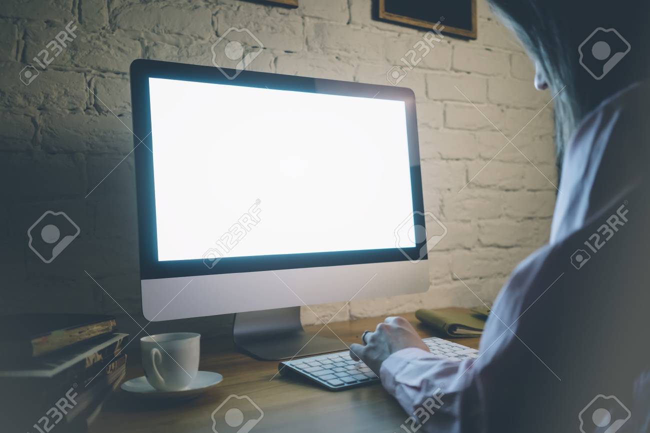 the girl working behind a computer keyboard and looking at the