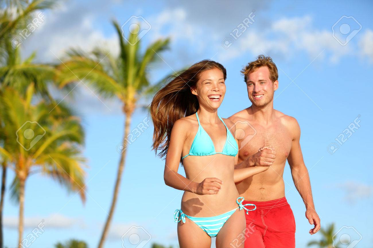 신혼여행 비키니 부부 함께 장난이 즐거운 실행 행복 웃고 해변 휴가 여행에서 재미. 수영복 비키니와 남자에서 여자. 하와이에서 신혼 여행에 사랑에  아름다운 간의 연인. 로열티 무료 사진, 그림, 이미지 그리고 스톡포토그래피. Image 26495958