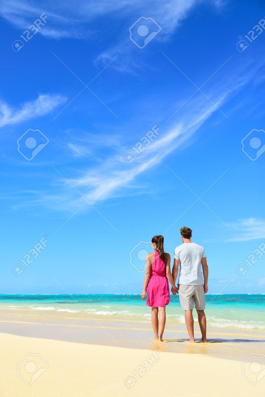 ビーチ休暇のカップルが夏の休暇にリラックスしました 若い人たちは海で 多くの青い空にコピー スペースと縦の収穫手を繋いでいる後ろから立っています 旅行の概念 の写真素材 画像素材 Image