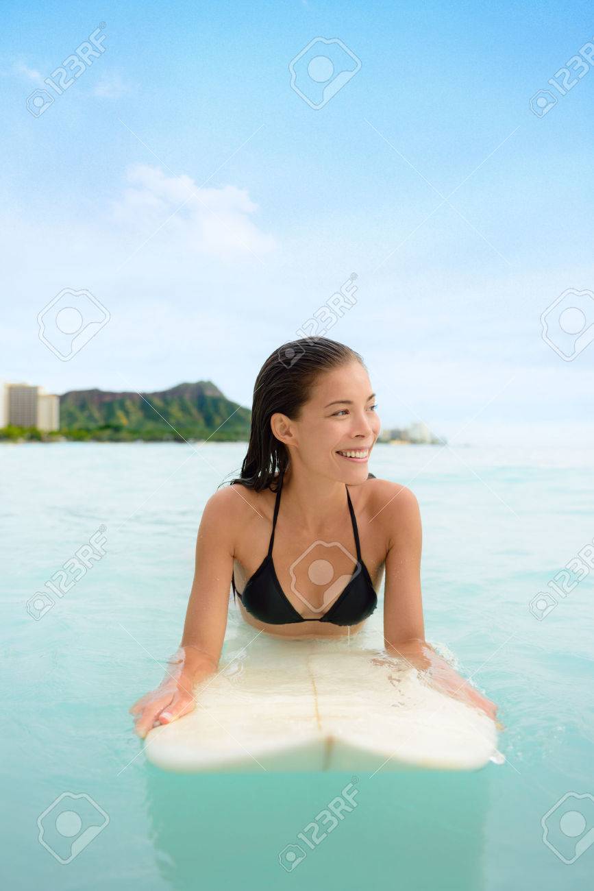 ワイキキ ハワイでサーフボードでサーフィン サーフ女性 ハワイ市 ホノルル オアフ島 ハワイ 米国でのサーフィン ボード上に横たわって海の波を待っているアジアの女の子の美しい肖像画 の写真素材 画像素材 Image