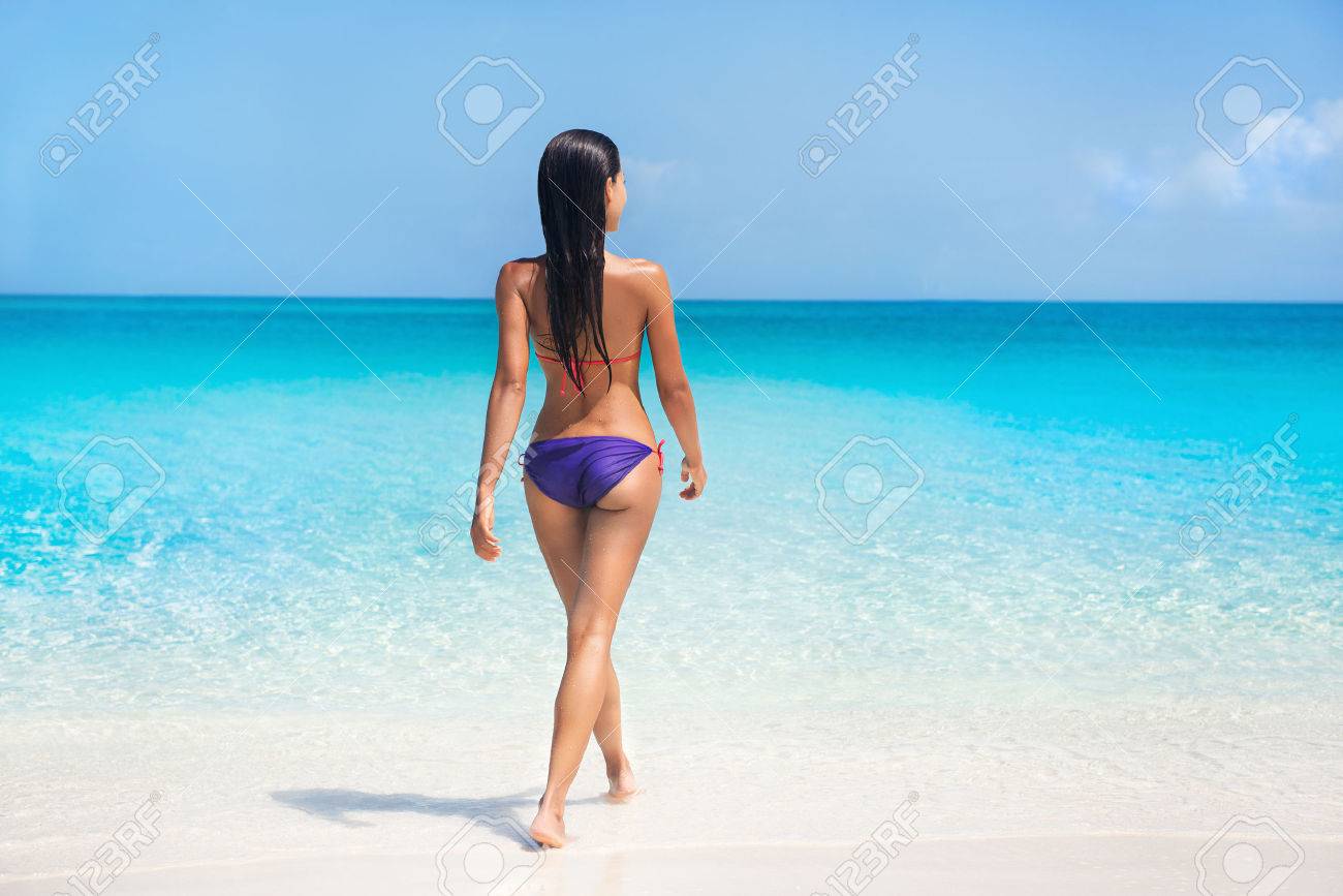 セクシーなビキニの体女性地 熱帯の夏のカリブ海旅行の楽園ビーチのターコイズ ブルーの海で泳いで 紫水着で日光浴に休暇をリラックス日焼け肌モデルします の写真素材 画像素材 Image