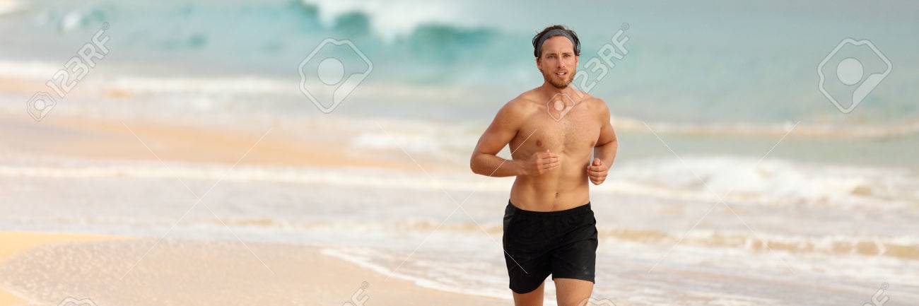 夕暮れ時のビーチをトップレス ショート パンツで走る男選手 男性フィットネス ランナー トレーニング心臓だけで 海を背景のバナーです 健康的なアクティブなライフ スタイル パノラマ横 Copyspace の写真素材 画像素材 Image