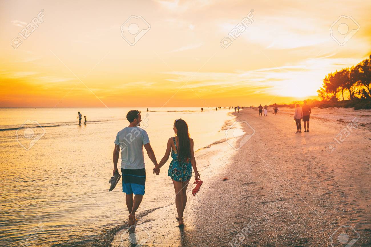Beach summer beach people lifestyle happy couple enjoying sunset walk on Shelling beach famous tourist destination on the southwest coast of Florida -Gulf of Mexico. Sanibel Island, Florida. - 117964219 Beach summer beach people lifestyle happy couple enjoying sunset walk on Shelling beach famous tourist destination on the southwest coast of Florida -Gulf of Mexico. Sanibel Island, Florida. - 117964219