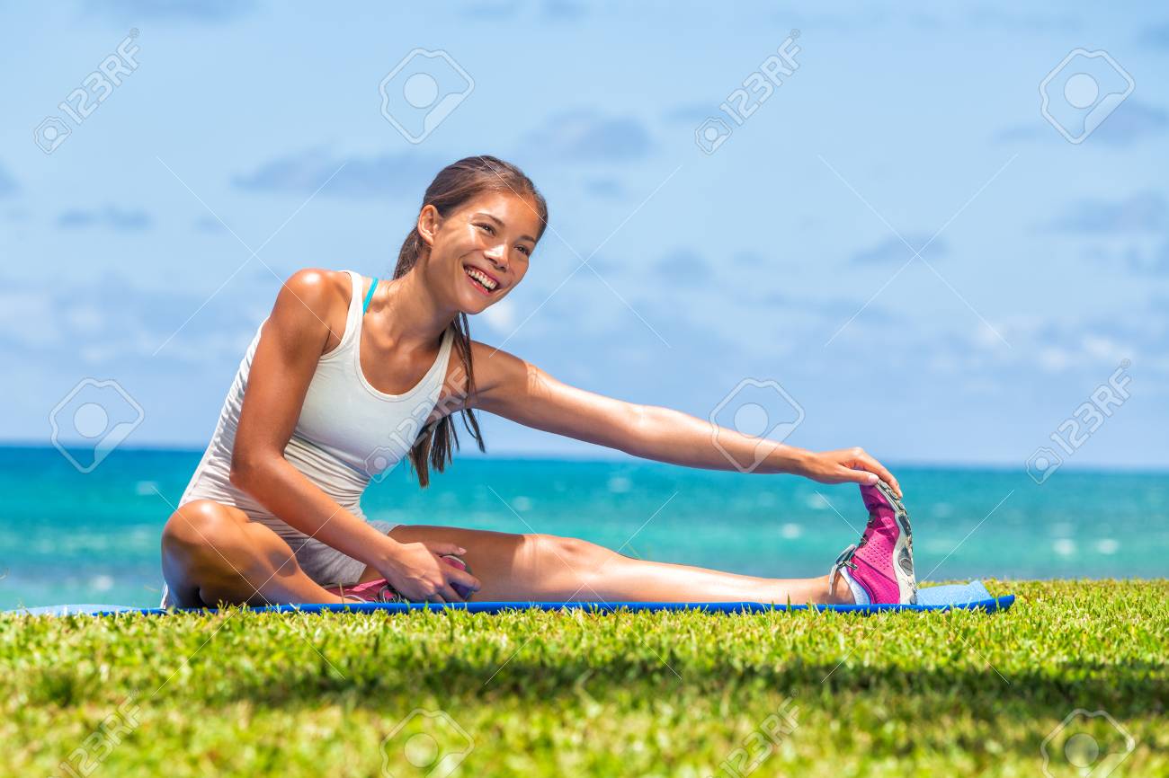 Fitness woman stretch legs doing warm-up before run workout training outdoor. Asian athlete stretching side hamstring muscle yoga stretched leg stretches exercises in outdoor gym. - 122804367 Fitness woman stretch legs doing warm-up before run workout training outdoor. Asian athlete stretching side hamstring muscle yoga stretched leg stretches exercises in outdoor gym. - 122804367
