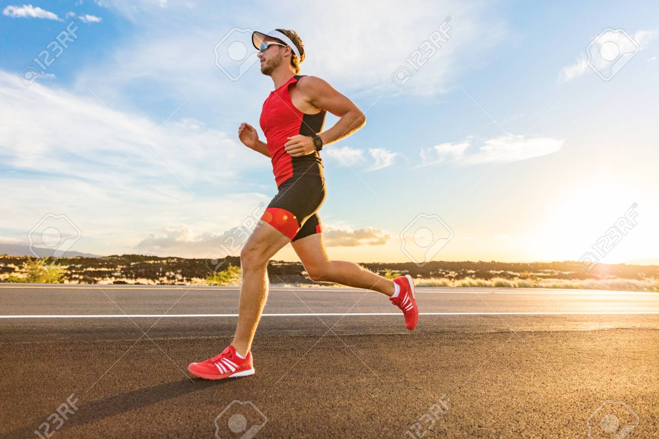 Triathlon - Triathlete man running in triathlon suit training for ironman race. Male runner exercising on Big Island Hawaii. Sunset. - 123633541 Triathlon - Triathlete man running in triathlon suit training for ironman race. Male runner exercising on Big Island Hawaii. Sunset. - 123633541