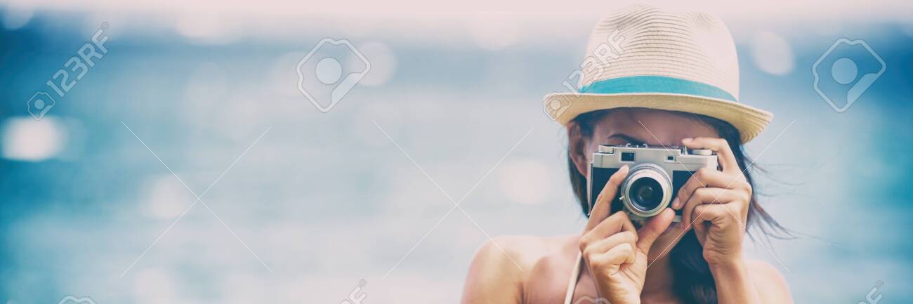Tourist photographer taking pictures on vintage retro film camera - woman at photography class taking photos. - 127252918 Tourist photographer taking pictures on vintage retro film camera - woman at photography class taking photos. - 127252918