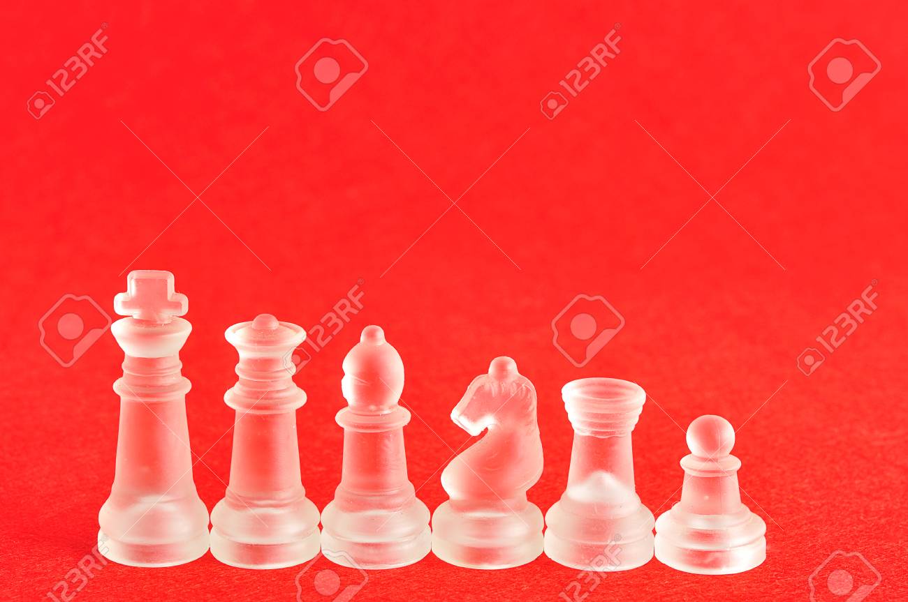 different chess pieces displayed on a red background stock photo